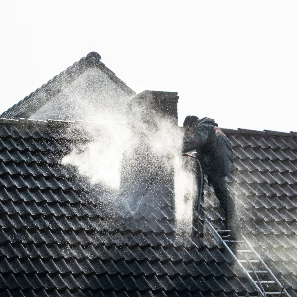 Technician soft washing a roof in Eugene, Oregon